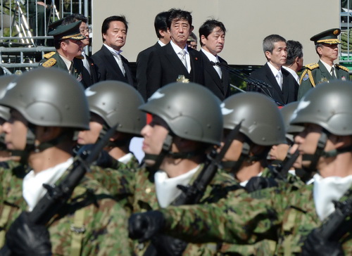 Thủ tướng Nhật Bản Shinzo Abe (giữa) quan sát binh sĩ thuộc Lực lượng phòng vệ Nhật diễu hành tại một khu huấn luyện quân đội ở ngoại ô Tokyo - Ảnh: AFP