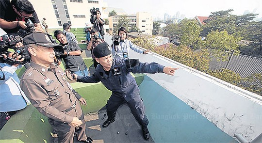 Tướng Jarumporn Suramanee (trái) đưa báo chí đi khảo sát nóc trụ sở Bộ Lao động - nơi nhóm cảnh sát áo đen đóng quân hôm 26-12. Ảnh: Bangkok Post