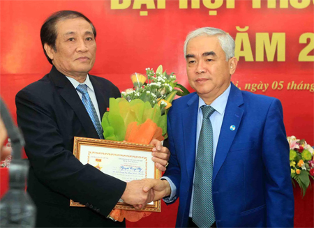 Ông Lê Hùng Dũng tặng hoa và kỷ niệm chương cho nguyên VFF Chủ tịch Nguyễn Trọng Hỷ - Ảnh: Gia Hưng