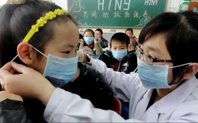 Trẻ em Trung Quốc được đeo khẩu trang để phòng chống lây lan cúm H7N9 (Ảnh AP)