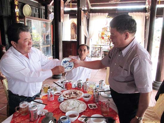 Thầy giáo Nguyễn Văn Thắm trao dĩa trà cổ cho chủ mới là Đặng Ngọc Hân trong buổi giao lưu cổ vật đầu xuân tại nhà hàng Đông Dương.
