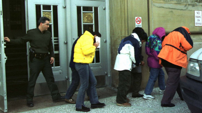 Quan chức nhập cư Mỹ di lý sáu công dân Trung Quốc ra khỏi tòa án liên bang ở Buffalo do nhập cư trái phép qua ngả Canada - Ảnh: Reuters