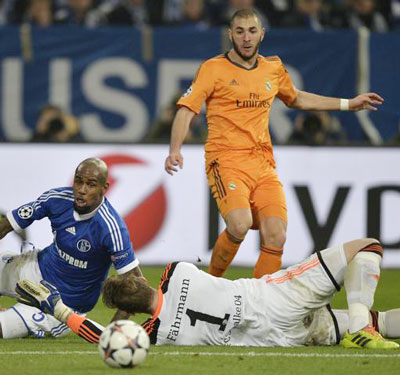 Tiền đạo Karim Benzema (áo cam) ung dung ghi bàn vào lưới thủ môn Ralf Faehrmann của Schalke. Ảnh: AP.