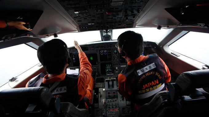 Các phi công cứu hộ Nhật quan sát mặt biển từ buồng lái máy bay tìm kiếm - Ảnh: Reuters