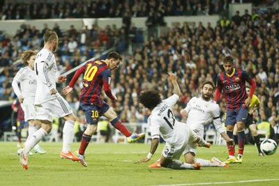 Tiền đạo Lionel Messi (số 10) tung cú sút giữa vòng vây của các hậu vệ Real Madrid. Ảnh: AP.