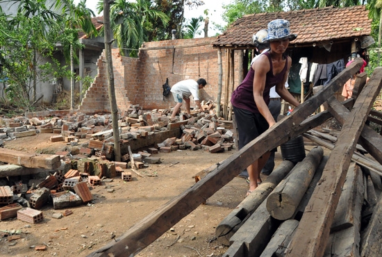 Chị Đinh Thị Liên- ngụ xã sơn Giang, Sơn Hà nhặt nhạnh những khúc đà còn sót lại sau khi ngôi nhà đã bị ngã đổ hoàn toàn