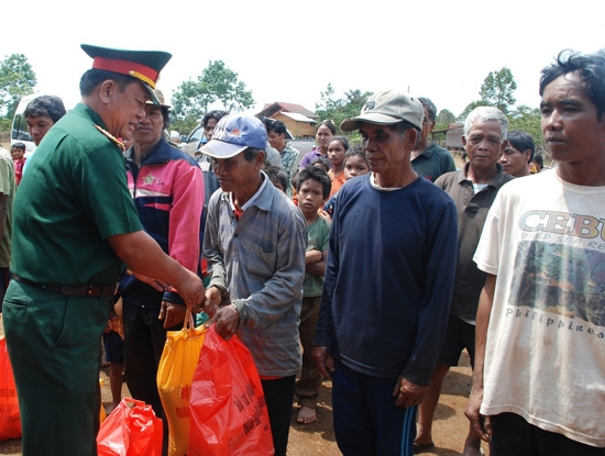 Đại tá Trần Xi Noa - Phó Chính ủy Bộ CHQS tỉnh tặng quà cho nhân dân bản Tà Ót, huyện Péc Xoòng, huyện Chămpasắc, Lào.