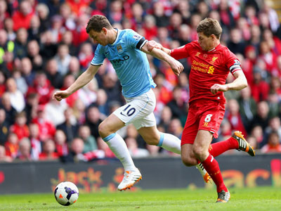 Edin Dzeko (số 10 - Man.City) nỗ lực đi bóng trước Steven Gerrard của Liverpool.