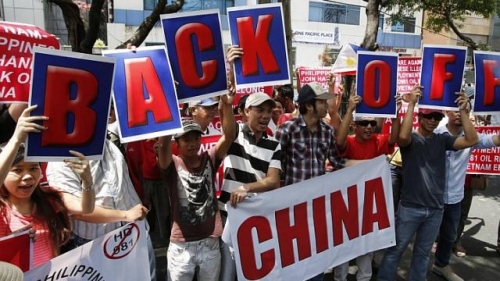 Những người biểu tình giơ cao khẩu hiệu phản đối Trung Quốc (Ảnh AFP)