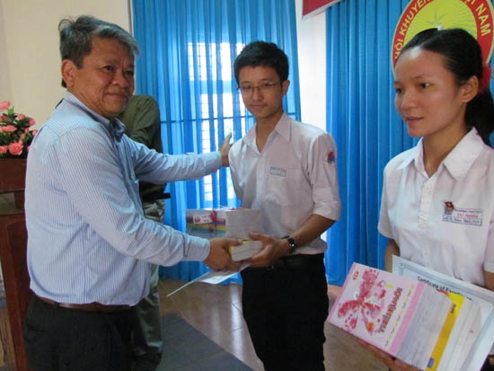 Ông Đoàn Thế Vinh, đại diện nhóm cựu học sinh Trường IVS Quảng Ngãi trao học bổng cho các em.