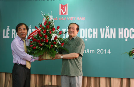  Chủ tịch Hội Nhà văn VN Nguyễn Hữu Thỉnh trao quyết định và tặng hoa lãnh đạo trung tâm, nhà văn Nguyễn Quang Thiều. Ảnh: Hữu Đỗ.