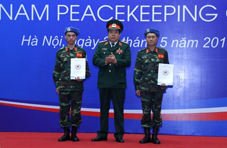  Bộ trưởng Bộ Quốc phòng Phùng Quang Thanh trao Quyết định cho hai sĩ quan làm nhiệm vụ gìn giữ hòa bình LHQ tại Nam Sudan. Ảnh: VGP/Đình Nam