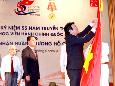 Chủ tịch nước Trương Tấn Sang gắn Huân chương Hồ Chí Minh lên lá cờ truyền thống của Học viện Hành chính Quốc gia.