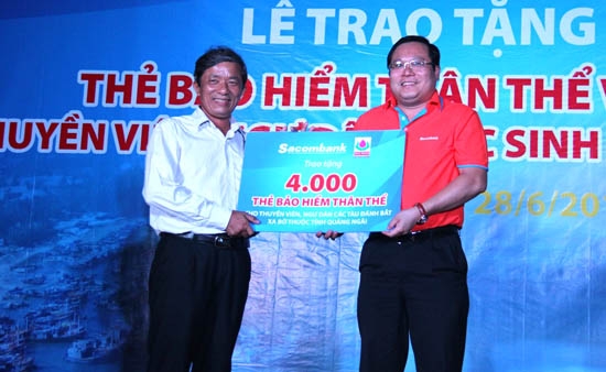 Ông Lê Văn Sáu – Chủ tịch UBMTTQ Việt Nam tỉnh đại diện 4.000 ngư dân Quảng Ngãi nhận thẻ bảo hiểm thuyền viên do ông Phan Huy Khang - Tổng giám đốc Sacombank trao tặng