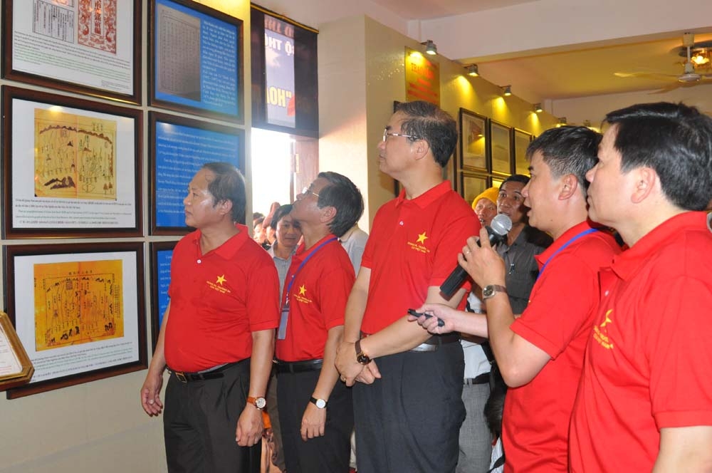 Lãnh đạo tỉnh Quảng Ngãi và các đại biểu tham quan, nghe giới thiệu về các tài liệu được trưng bày tại triển lãm.