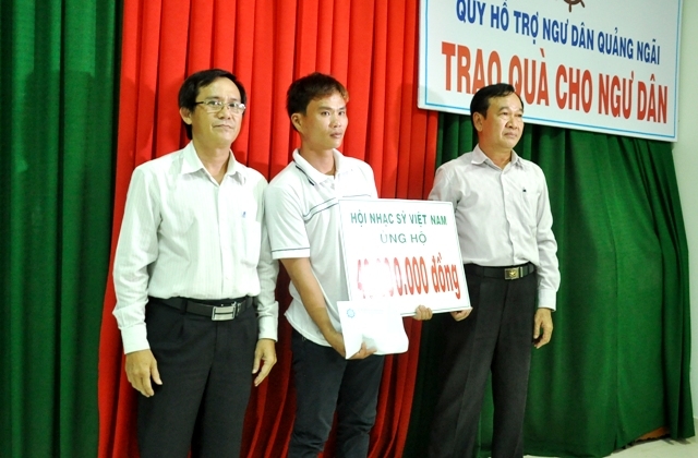 Ngư dân Nguyễn Chí Thạnh (ở giữa) nhận tiền ủng hộ cảu Hội Nhạc sĩ Việt Nam