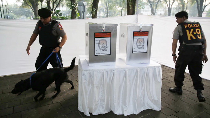Cảnh sát Indonesia kiểm tra an ninh tại một điểm bầu cử nơi ứng cử viên tổng thống Joko Widodo sẽ đến bỏ phiếu - Ảnh: Reuters