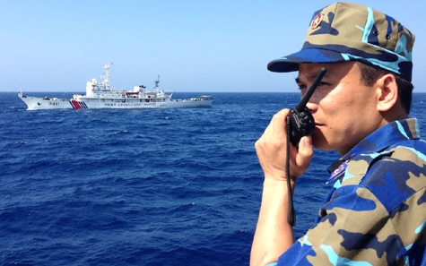 Trong ảnh là thuyền trưởng tàu cảnh sát biển 8003 của Việt Nam ở phía tây quần đảo Hoàng Sa. Áp sát phía trên là một tàu tuần duyên Trung Quốc (ảnh: Bloomberg)