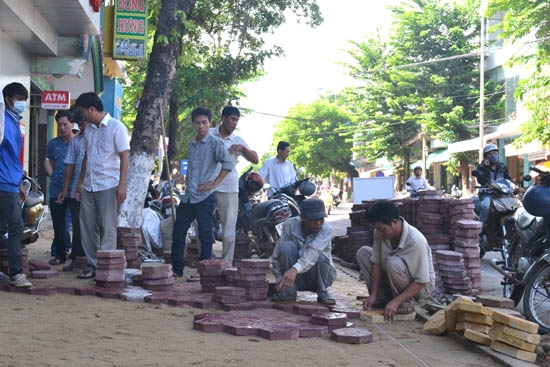 Công nhân đang triển khai lát gạch vỉa hè đường Quang Trung.