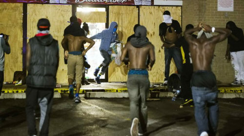   Nhiều thanh niên cướp phá một cửa hàng ở Ferguson hôm qua - Ảnh: Reuters
