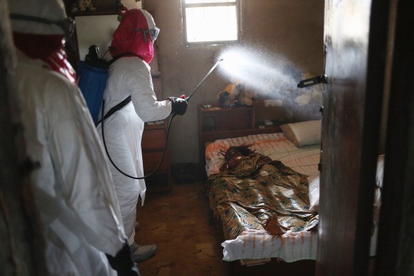Bác sĩ phun thuốc khử trùng tại nhà một bệnh nhân chết vì Ebola ở Liberia. Ảnh: Getty