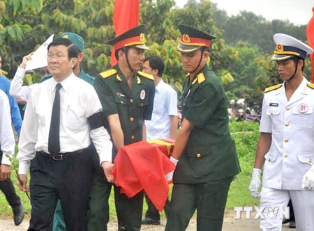 Chủ tịch nước Trương Tấn Sang tham gia nghi thức an táng hài cốt liệt sỹ. (Ảnh: Sỹ Tuyên/TTXVN)