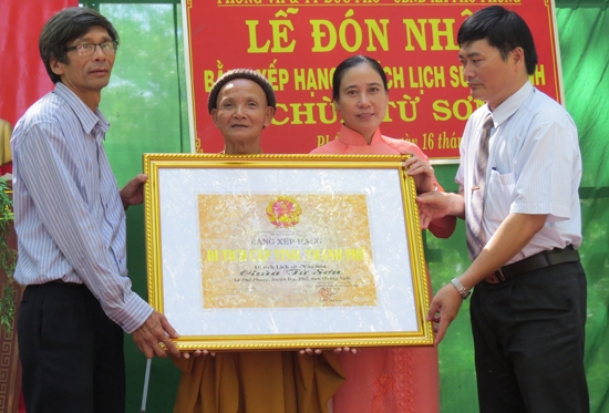 Tiến sĩ Đoàn Ngọc Khôi (bên trái) – Phó Giám đốc Bảo tàng tổng hợp tỉnh trao Bằng xếp hạng di tích lịch sử cấp tỉnh cho đại diện lãnh đạo địa phương và nhà chùa.