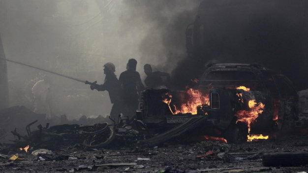 Khói lửa bốc lên từ một khu chợ trung tâm thành phố Raqa sau khi quân đội Syria không kích các mục tiêu IS Ảnh: Reuters