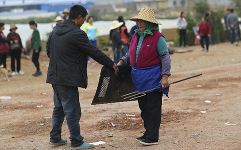 Một người dân nhặt các loại vũ khí sau vụ ẩu đả (Ảnh Reuters)