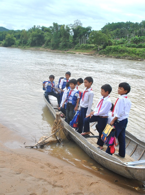 Học sinh xã Sơn Bao sang sông trên chiếc ghe nhỏ. Ảnh: LÊ ĐỨC