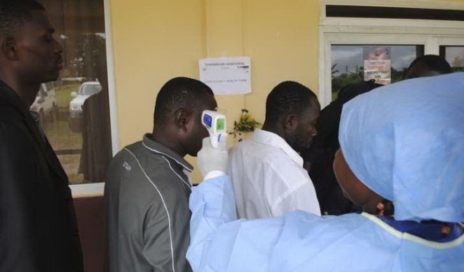  Nhân viên y tế đo thân nhiệt những người tham dự một cuộc họp báo về việc mở một trung tâm điều trị Ebola mới ở Monrovia hôm 3-10 - Ảnh: Reuters