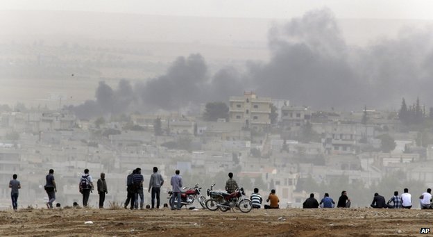 Người dân hướng tầm mắt về khu vực giao tranh thuộc Kobane tại một nơi an toàn ở Thổ Nhĩ Kỳ