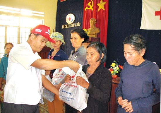 Ông Đặng Văn Mỹ - Chủ tịch Hội Chữ thập đỏ tỉnh tặng quà cho người nghèo xã Bình Châu (Bình Sơn).                                                                                                 Ảnh: VŨ YẾN