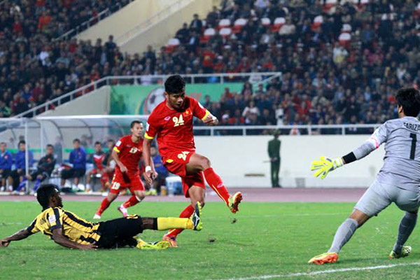 Hậu vệ Malaysia phá bóng ngay trong chân Hải Anh. Ảnh: Lâm Thỏa/VnExpress