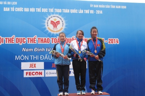 Phạm Thị Bình (giữa) và chiếc HCV cự ly marathon ở đại hội. Ảnh: K.Xuân