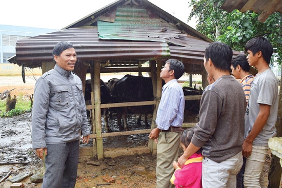 Ông Đinh Tấn Sơn(bên trái) trao đổi kinh nghiệm chăn nuôi gia súc cho người dân trong thôn.