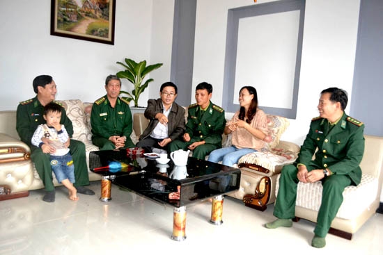 Đồng chí, đồng đội đến chúc mừng gia đình trung úy Phan Tấn Ba  (thứ 3 từ phải qua)  có được ngôi nhà mới.