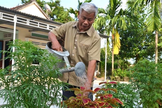 Ông Phạm Lừa đang chăm sóc vườn hoa của mình.
