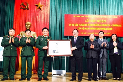 Thứ trưởng Bộ TT&TT Trương Minh Tuấn trao tặng bộ tư liệu và bản đồ về 2 quần đảo Hoàng Sa và Trường Sa cho BĐBP. Ảnh: VGP/Thúy Hà
