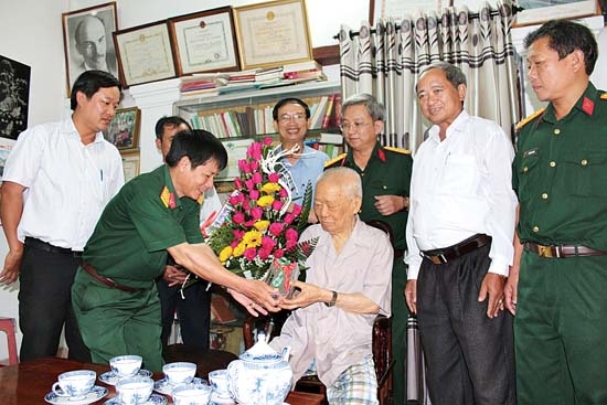 Đại tá Đặng Hữu Thọ - Phó chỉ huy trưởng Bộ CHQS tỉnh tặng quà cho Trung tướng Nguyễn Đôn, nguyên Chính trị viên Đội Du kích Ba Tơ. Ảnh: T.HÂN
