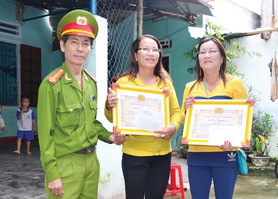  Công an phường Nghĩa Chánh trao giấy khen của Giám đốc Công an tỉnh cho chị Nở và chị Lan về thành tích dũng cảm trong tấn công tội phạm.