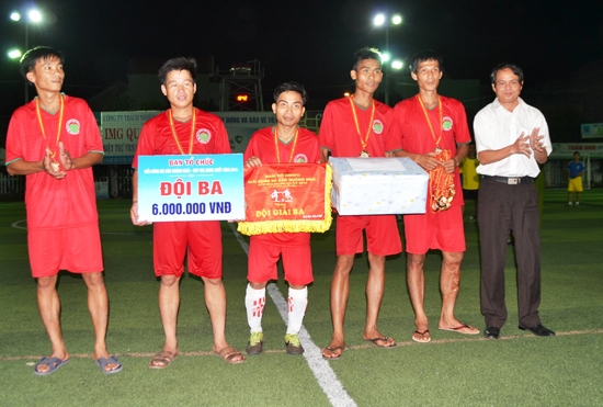 Phó Chủ tịch LĐBĐ tỉnh Nguyễn Trung Quân (bên phải) trao giải ba cho đội Công ty Môi trường đô thị Quảng Ngãi tại Giải bóng đá Báo Quảng Ngãi - Cúp Bia Dung Quất năm 2014.