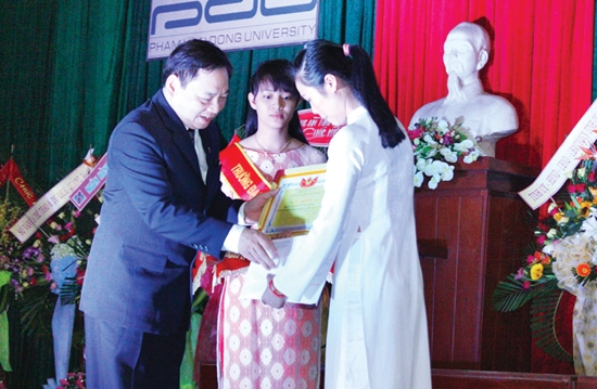 PGS, TS Phạm Đăng Phước- Hiệu trưởng Trường ĐH Phạm Văn Đồng trao học bổng cho sinh viên Nguyễn Thị Bích Phượng.