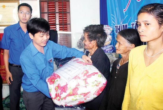 Anh Võ Thành Tâm-Bí thư Đoàn Khối CCQ tỉnh tặng quà cho đồng bào nghèo ở huyện Tây Trà.                                                Ảnh: LÊ DANH