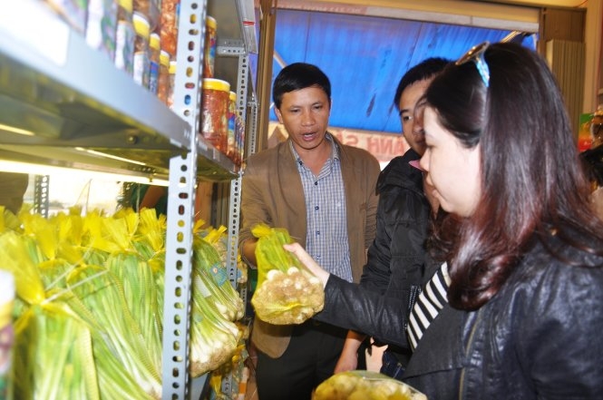 Anh Định (trái) giới thiệu sản phẩm tỏi Lý Sơn cho người tiêu dùng - Ảnh: Trần Mai