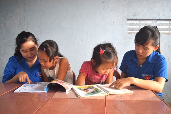  Đoàn viên Chi đoàn Hành chính huyện Bình Sơn hướng dẫn chị em cháu Huỳnh Thị Kim Chung  làm bài tập.