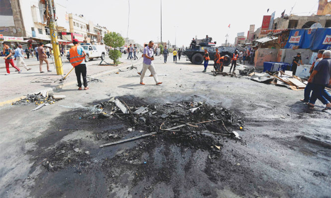  Hiện trường vụ bom xe phát nổ ngày 27-6 gần khu các cửa hàng bán phụ tùng xe hơi tại Baghdah - Ảnh: Reuters