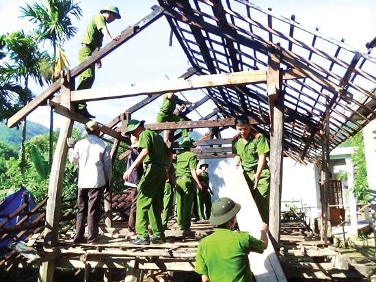 Cán bộ, chiến sĩ Công an huyện Minh Long giúp dân dỡ dọn nhà cửa.                           ảnh: BS