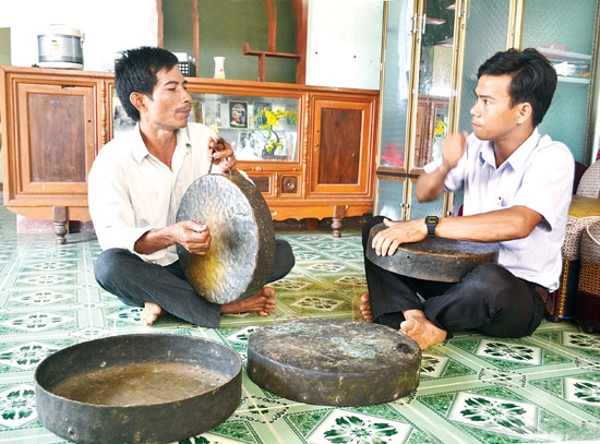 Ông Đinh Văn Trui (bên trái) trao đổi việc đánh chiêng với anh Đinh Văn Mây.