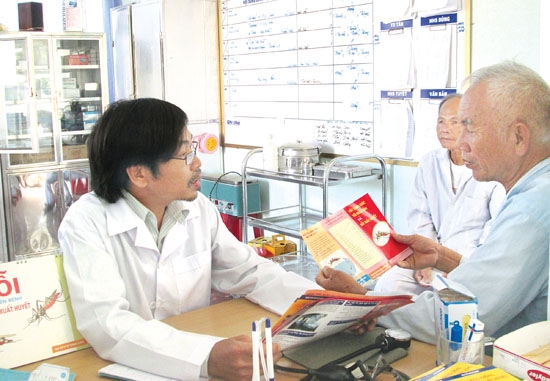 Cán bộ y tế xã Đức Lợi (Mộ Đức) đang tư vấn cho người dân về cách phòng chống bệnh sốt xuất huyết.